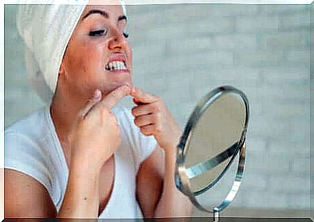 A young woman pressing a button in front of a mirror. 