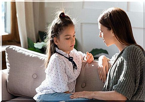 A mother and her daughter talking about feelings on the sofa.