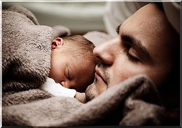 Baby sleeping on her sleeping daddy 