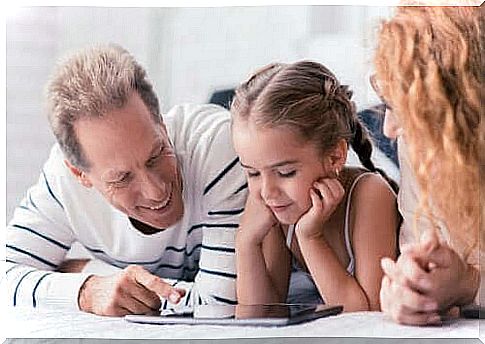 parents using a tablet with their daughter