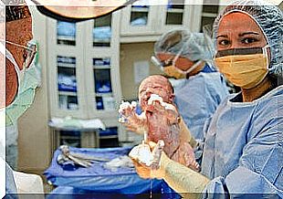 A newborn baby in the hands of a nurse, after choosing between cesarean section and childbirth 