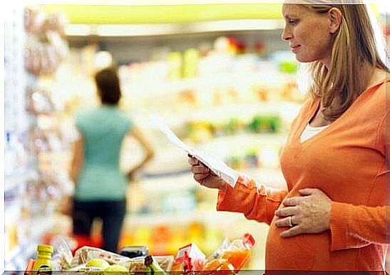 Pregnant woman with a shopping list in the supermarket