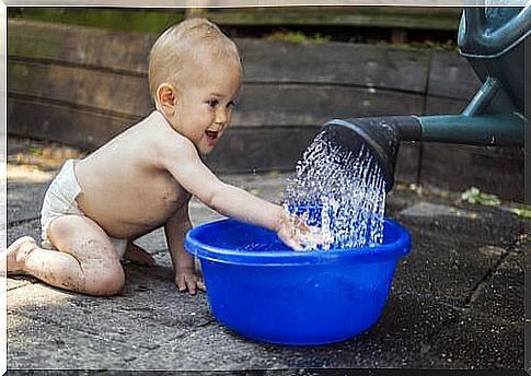 A baby plays with water