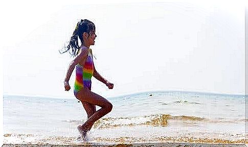 A young girl running on the beach.