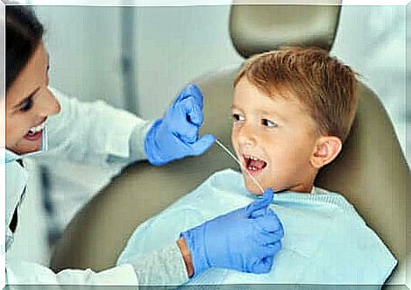 A dentist flossing through a child's mouth. 