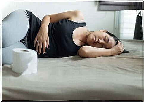 woman lying on her side facing toilet paper