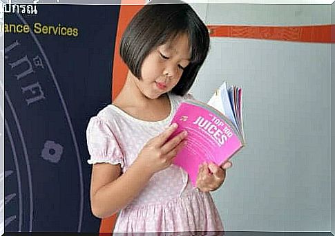 A little girl reads a book in English