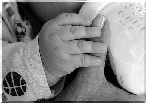 A baby drinks breast milk from a bottle, thanks to the establishment of a milk bank by his mother