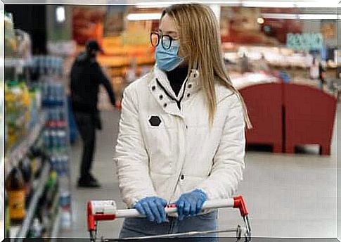 A woman wearing a mask and gloves shopping