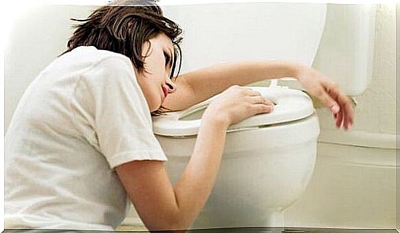 Woman above toilet suffering from nausea during pregnancy