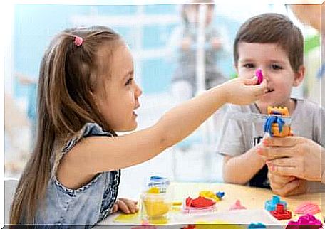 Two children playing plasticine. 